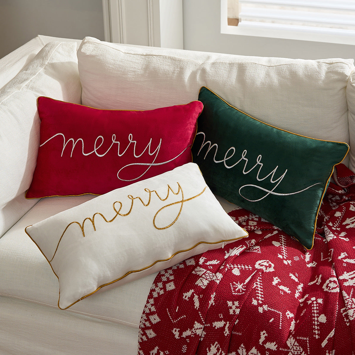 Housse de coussin de Noël « Merry » posée sur un canapé, format 30 × 50 cm — MaisonFAME