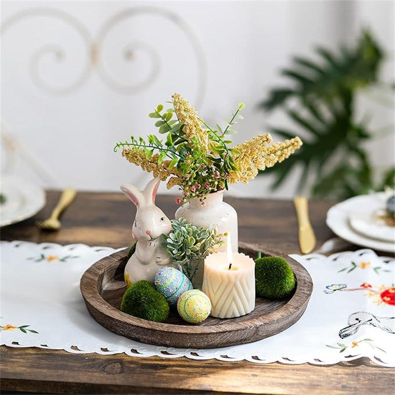 Plateau rond en bois MaisonFAME dressé avec bougies, verdure et petite décoration de fêtes