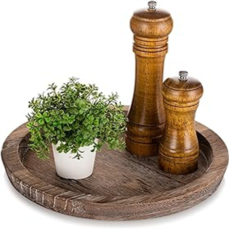 Plateau rond en bois MaisonFAME posé sur une table avec un moulin à poivre et une petite plante verte