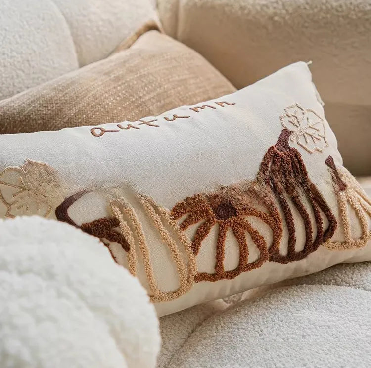 Coussin citrouille en peluche posé sur un canapé, ambiance cocooning d'automne — MaisonFAME