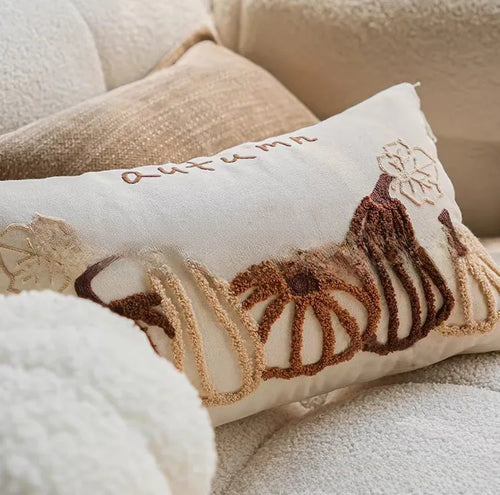Coussin citrouille en peluche posé sur un canapé, ambiance cocooning d'automne — MaisonFAME
