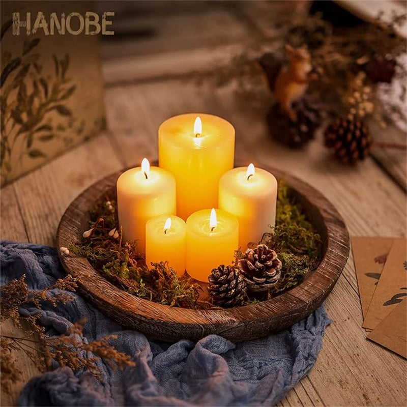 Plateau rond en bois MaisonFAME avec bougie allumée, pommes de pin et mousse décorative