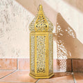 Lanterne marocaine MaisonFAME en métal doré avec motifs ajourés complexes créant des jeux d'ombre et de lumière.
