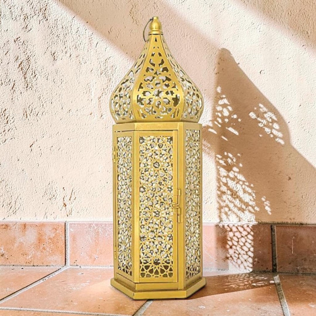 Lanterne marocaine MaisonFAME en métal doré avec motifs ajourés complexes créant des jeux d'ombre et de lumière.